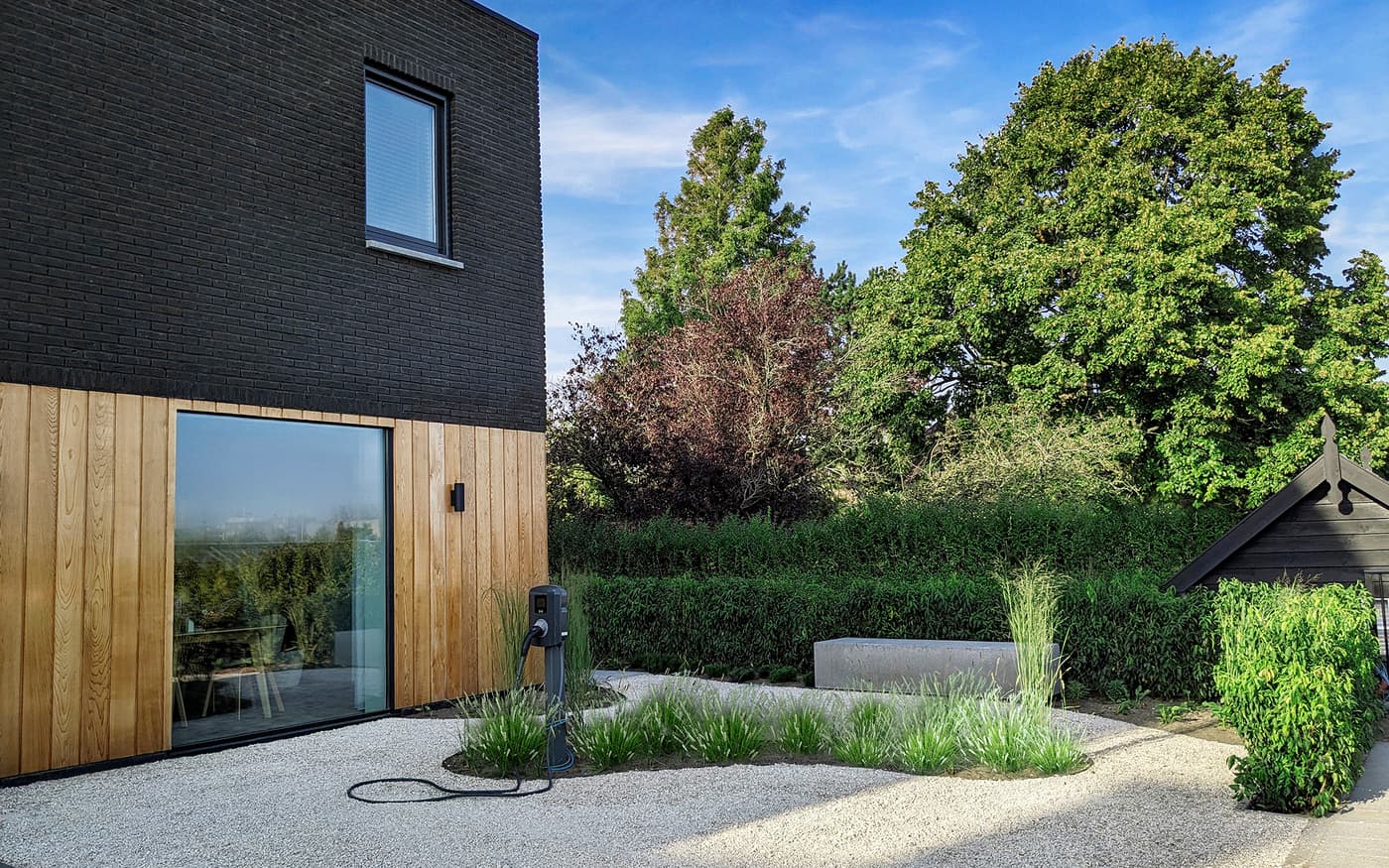 Woonhuis Rijswijk, gevel van zwart metselwerk en hout met tuin